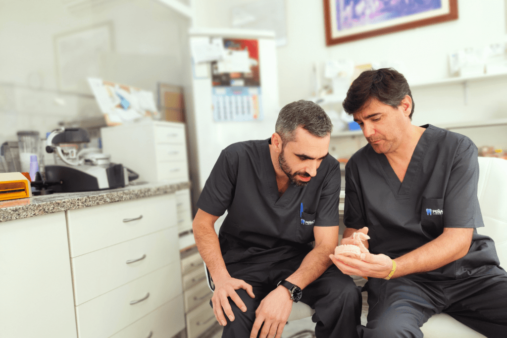 Los protésicos de l laboratorio Peña Dental: José Ignacio Peña Bursón y Alfredo Vallo Ruiz, mirando un modelo de trabajo.